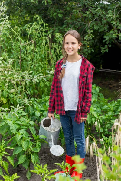 Happy teen girl posing with watering can at garden — Stock Photo, Image