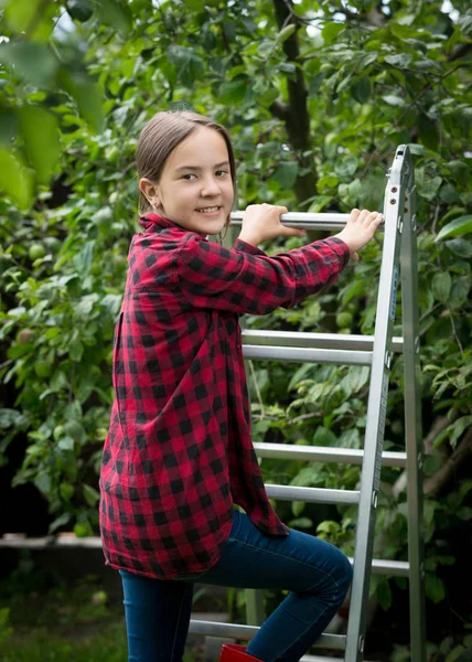 Beautiful smiling teenage girl in red checkered shirt climbing u — Stock Photo, Image