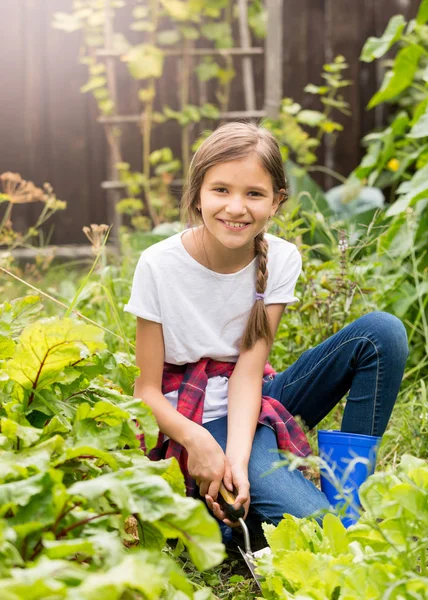 Happy smiling teenage girl planting lettuce at garden at sunny d — Stock Photo, Image