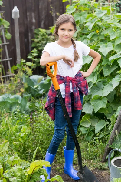 Smiling young girl working at garden with shovel — Stock Photo, Image