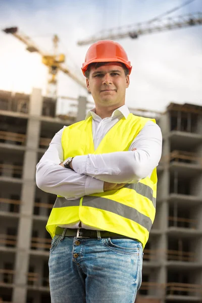 Portrait of smiling architect in hardhat standing against buildi — Stock Photo, Image