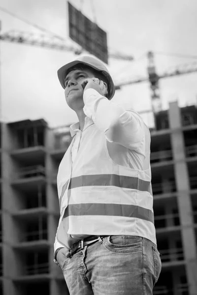 Black and white portrait of young construction engineer talking — Stock Photo, Image