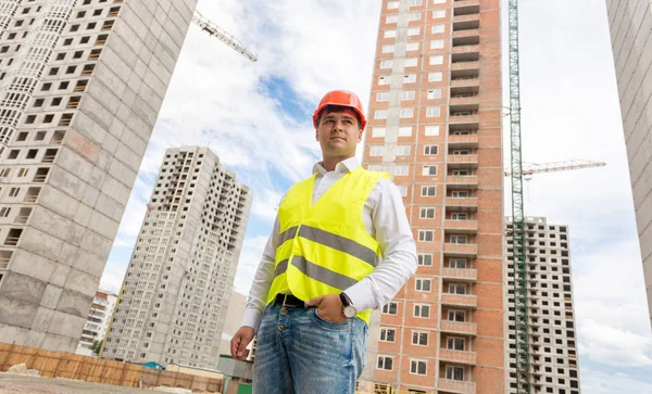 İnşaat alanına karşı kask içinde genç mühendis