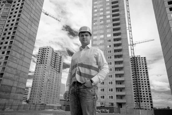 Zwart-wit portret van lachende ingenieur poseren tegen buil — Stockfoto