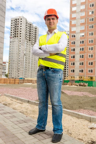 Construction engineer standing in front of buildings under const — Stock Photo, Image