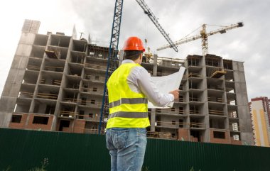 Genç mühendis bina sitesi planları inceliyor