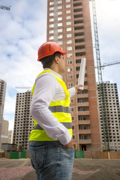 Bauingenieur zeigt auf Gebäude im Bau — Stockfoto