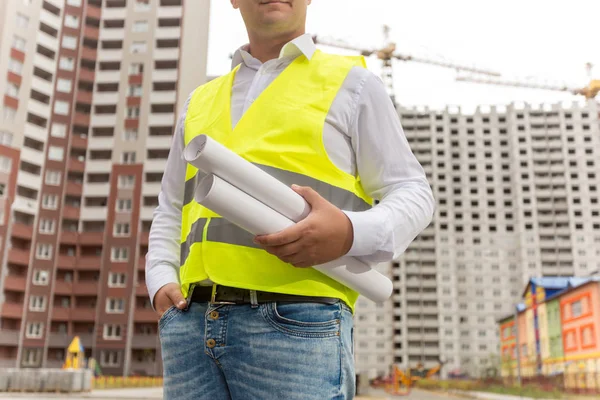 Primer plano del ingeniero masculino que sostiene planos y documentos —  Fotos de Stock