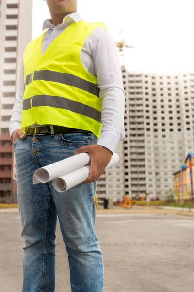 Construction engineer standing at building site and holding blue — Stock Photo, Image