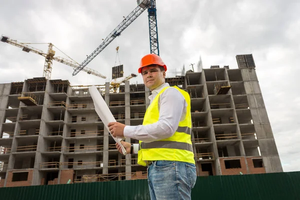 Ingenieur in rotem Bollenhut steht auf Baustelle und checki — Stockfoto