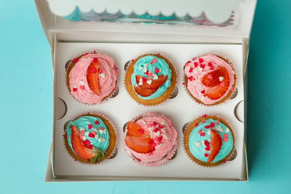 Vista de cima em cupcakes com polvilhas e morango em caixa — Fotografia de Stock