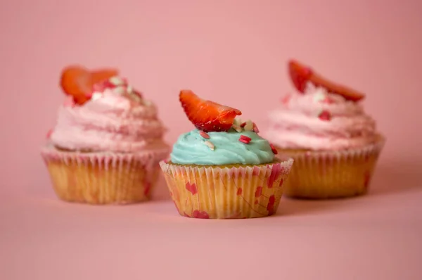 Three decorated cupcakes with blue and pink buttercream — Stock Photo, Image