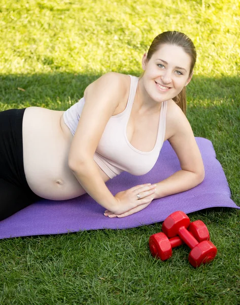 Portrait of smiling pregnant woman standing on knees on fitness — Stock Photo, Image