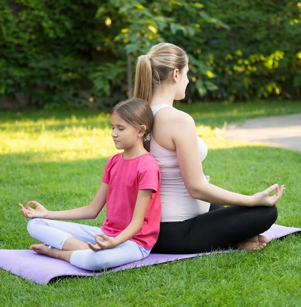 Feliz madre e hija sonriente practicando yoga y sentada ba — Foto de Stock