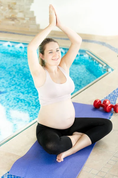 Jovem grávida fazendo ioga no tapete de fitness ao lado do sw — Fotografia de Stock
