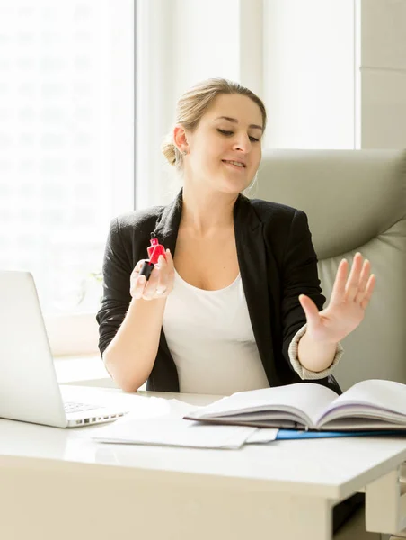 Schöne junge Sekretärin lackiert Fingernägel statt workin — Stockfoto