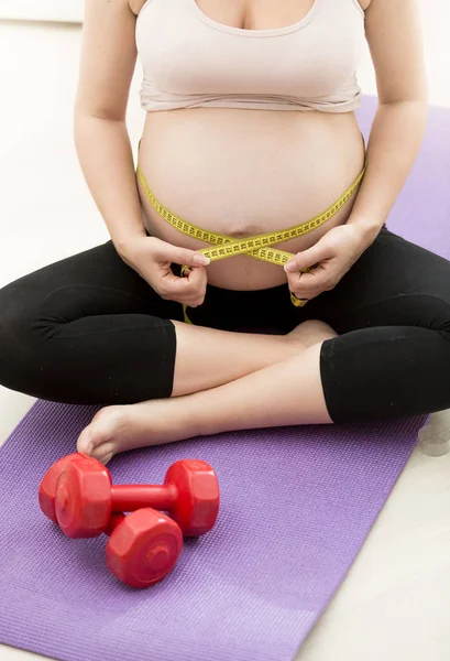 Gravid kvinna mäta magen med tejp — Stockfoto