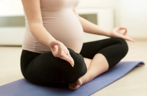自宅で練習ヨガ妊娠中の女性のクローズ アップ画像 — ストック写真