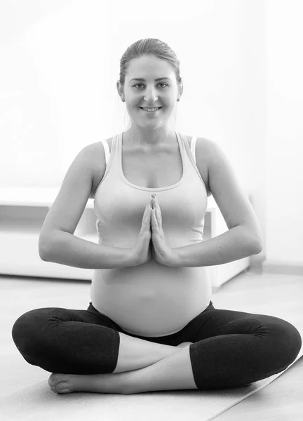 Czarno-białe zdjęcie uśmiechający się kobieta w ciąży, ćwiczenia jogi — Zdjęcie stockowe