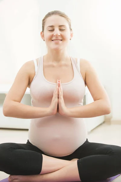 Sorridente donna incinta che pratica yoga — Foto Stock