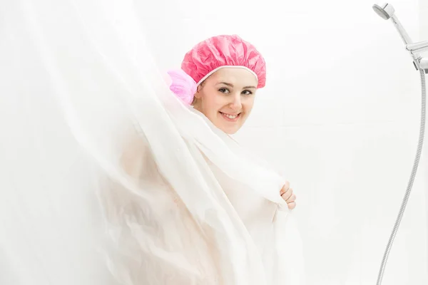 Portrait de mignonne femme souriante portant un bonnet de douche ayant bain un — Photo