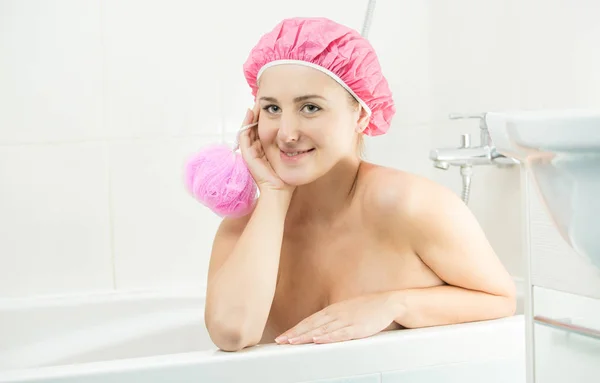 Szép mosolygó nő visel zuhanyzó sapka feküdt, a fürdő és a vécé — Stock Fotó