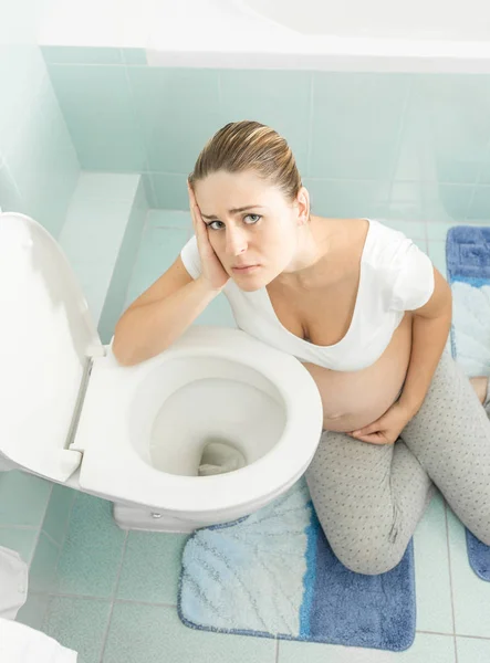 Portrait of young pregnant woman suffering from intoxication and — Stock Photo, Image
