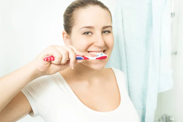 Portret van mooie brunette vrouw tanden poetsen — Stockfoto