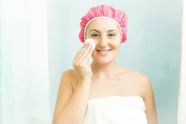 Retrato de mulher sorridente usando creme facial depois de tomar banho — Fotografia de Stock