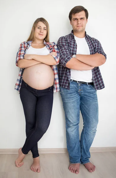 Feliz pareja sonriente esperando a que el bebé pose en jeans y camisetas — Foto de Stock