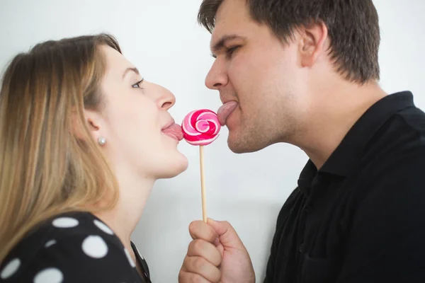 Portrait of smile couple in love licking red lollipop — Stok Foto