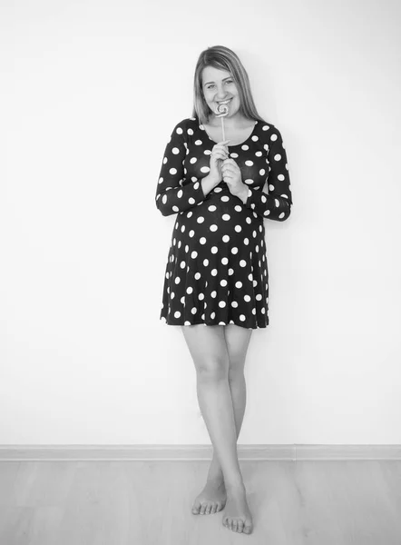 Schwarz-Weiß-Bild der niedlichen schwangeren Frau posiert mit Lollipo — Stockfoto