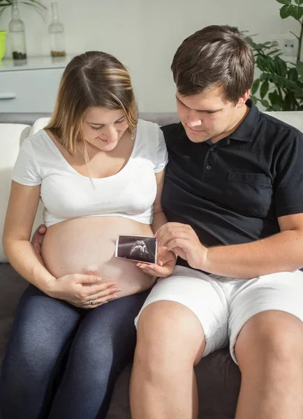 Happy pregnant couple looking on ultrasound baby scan — Stock Photo, Image