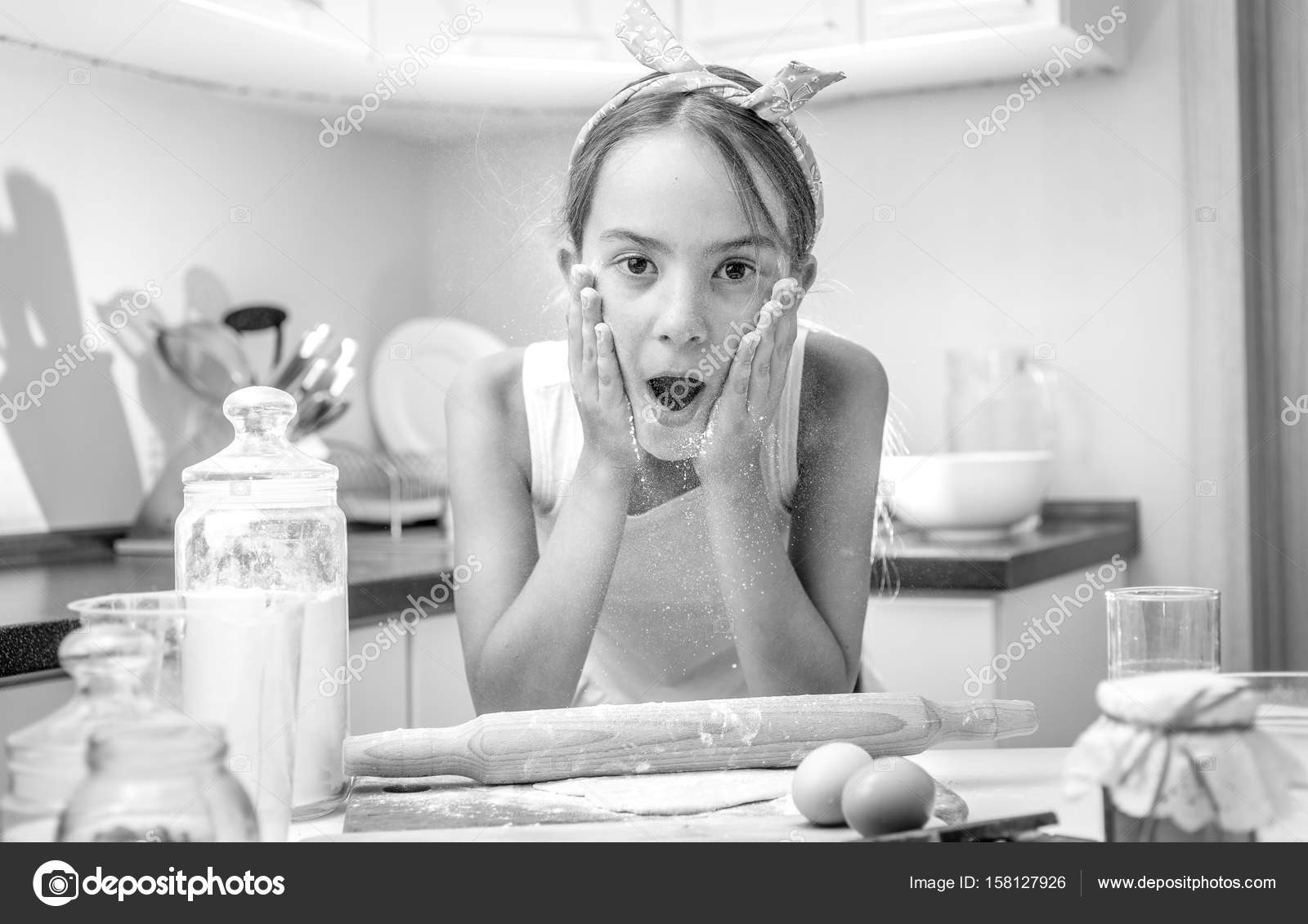 Black and white portrait of excited girl clapping on her cheeks Stock
