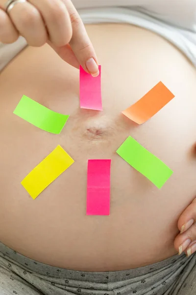 Konceptuell bild av gravid kvinna att göra val på färgglada mem — Stockfoto
