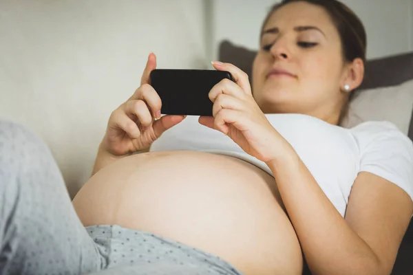 Foto de close-up da mulher grávida digitando mensagem no smartphone — Fotografia de Stock