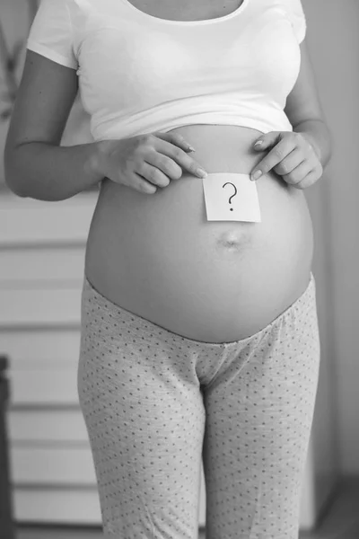 Siyah beyaz görüntü hamile po üzerinde çizilmiş soru işareti ile — Stok fotoğraf