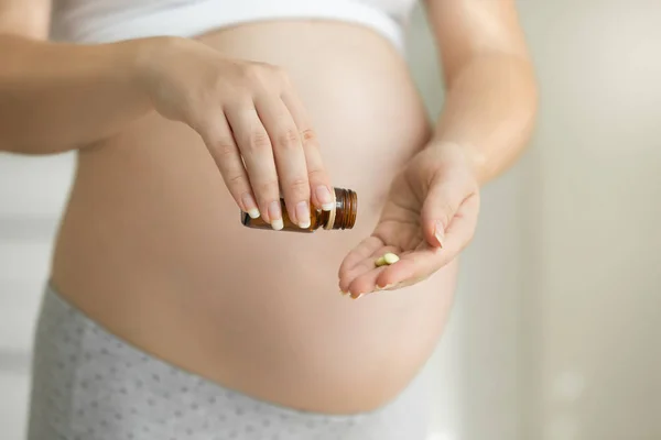 Imagem de close-up da mulher grávida segurando pílulas e medicamento bottl — Fotografia de Stock