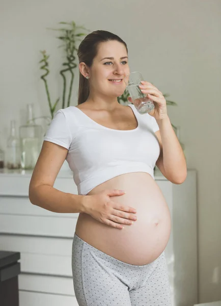 Retrato de mujer embarazada feliz posando con un vaso de agua a m — Foto de Stock