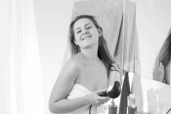 Retrato monocromático de una mujer joven secando el cabello después de haber mostrado — Foto de Stock