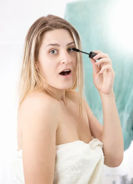 Verrast vrouw toepassing van make-up op badkamer — Stockfoto