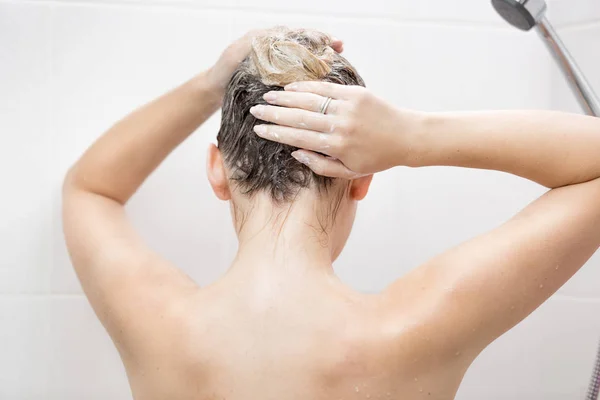 Вид со спины сексуальной женщины, моющей волосы шампунем — стоковое фото