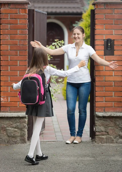 Gelukkig schoolmeisje uitgevoerd om haar moeder te wachten voor haar na sch — Stockfoto