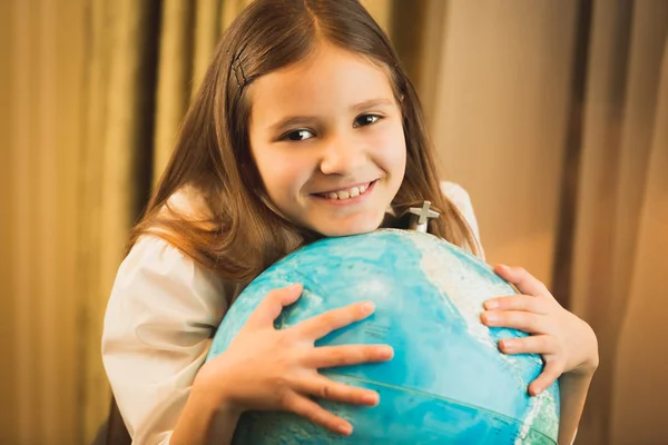 Портрет милої дівчини тримає руку на глобусі — стокове фото