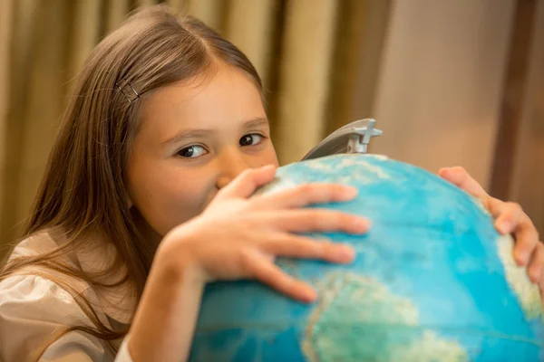 Portrait of cute girl holding hand on Earth globe — Stock Photo, Image