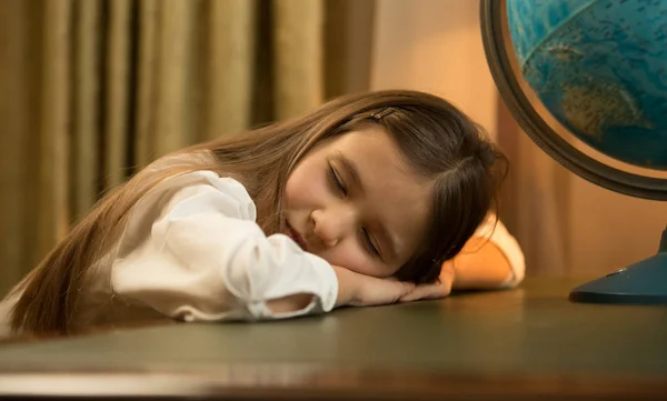 Portrait of cute tired schoolgirl sleeping on desk — Stock Photo, Image