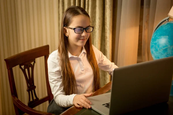 Nettes lächelndes Mädchen tippt Nachricht auf Laptop — Stockfoto