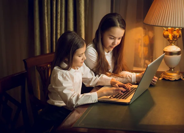 Portrait of two little sisters using laptop — Stock Photo, Image