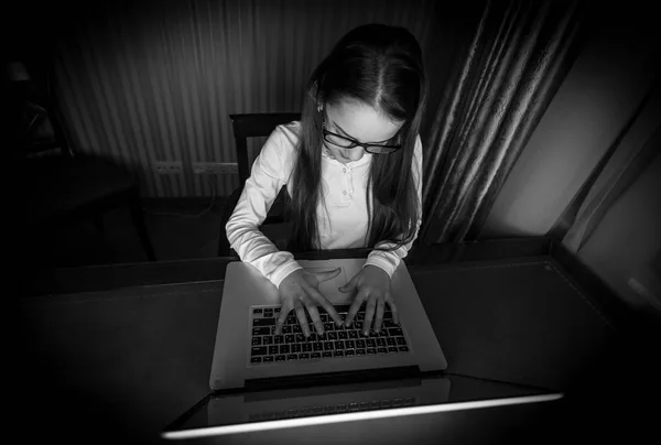 Black and white portrait of teenage girl sitting in dark room wi — Stock Photo, Image