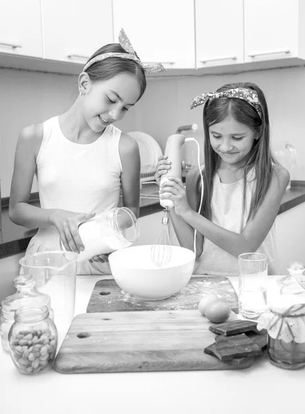 Ritratto in bianco e nero di due ragazze sorridenti che cucinano torta e ma — Foto Stock